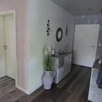 Flur mit Kleiderständer, Pflanze und Blick in Schlafzimmer