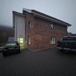 Zweistöckiges Haus mit Backsteinfassade und Parkplatz für zwei Fahrzeuge.