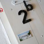 Tür mit Hausnummer 2b und Schild KÄLVSTALL. Rauchverbotsschild angebracht.