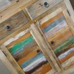 Holzschrank mit farbigen Türen und schwarzen Ringgriffen