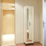 Dusche, Kleiderschrank und Waschbeckenbereich in einem Badezimmer