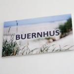 Schild mit der Aufschrift BUERNHUS vor Strandvegetation
