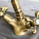 Antik-goldener Wasserhahn mit zwei Kurbeln und Markierung.
