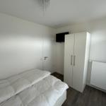 Schlafzimmer mit Bett, Kleiderschrank und Deckenventilator