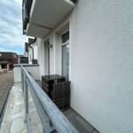 Balkon mit Tisch und zwei Stühlen, weißer Putz, Metallgeländer