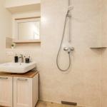 Bad mit Dusche, Waschbecken und Spiegel