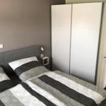 Schlafzimmer mit Doppelbett, Kleiderschrank und Stehlampe.