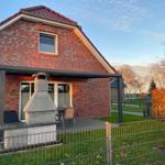 Rotes Backsteinhaus mit Terrasse und Grillplatz im Garten.