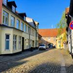 Kobolsteinstraße mit historischen Häusern und einem Tor im Hintergrund.