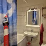 Badezimmer mit Duschvorhang, Waschbecken und Spiegel