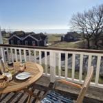 Terrasse mit Tisch und Stuhl, Blick auf Häuser und Meer.