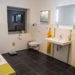 Badezimmer mit Badewanne, Waschbecken, Toilette und gelbem Schrank.
