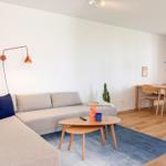 Wohn- und Essbereich mit Sofa, Tisch und Stühlen.