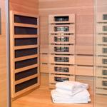 Sauna mit Holzwand, Heizung und gefalteten Handtüchern.