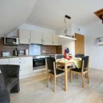 Küche mit Essbereich, Sofa und Treppe zur oberen Etage.