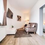Wohnbereich mit Sofa, Fernseher und Blick in Schlafzimmer