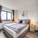 Schlafzimmer mit Doppelbett, Fenster mit Blick und Nachttischen.