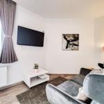 Wohnzimmer mit Sofa, Fernseher und Wandbild