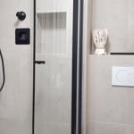 Dusche mit Glaswand, Toilette und Badewanne im Badezimmer