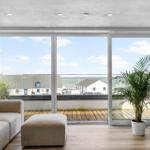 Wohnzimmer mit großem Fenster und Blick auf den Hafen.
