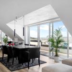 Essbereich mit Tisch und Stühlen, große Fenster mit Balkonblick, Zimmer mit Fernseher und Sofa.