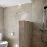 Badezimmer mit Dusche, Toilette und Fenster