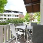Terrasse mit Tisch und Stühlen, Blick auf Wohnhaus und Bäume