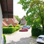 Parkplatz mit mehreren Autos und grünen Bäumen im Hintergrund.