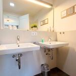 Zwei Waschbecken mit Spiegeln und Handtuchhaltern an der Wand.