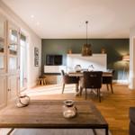 Wohn- und Essbereich mit Holzboden, Esstisch, TV und Schrank
