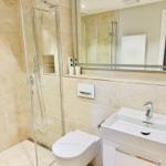 Badezimmer mit Dusche, Toilette und Waschbecken.