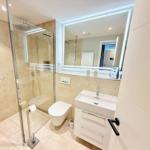 Moderne Badewanne mit Dusche, Waschbecken und Toilette.