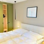 Schlafzimmer mit Bett, Kleiderschrank und Wandbild.
