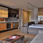 Moderne Einzimmerwohnung mit Küche, Schlafbereich und Sitzgelegenheit.