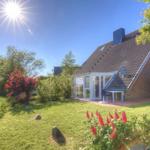 Haus mit Garten, Sonne, roten Blumen und Terrasse