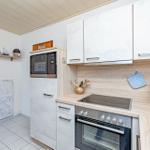 Küche mit Dunstabzug, Herd, Kühlschrank und Arbeitsfläche.