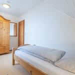 Ein Schlafzimmer mit einem Bett, einem Kleiderschrank und einer Tür.
