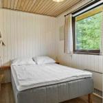Schlafzimmer mit Bett, Fenster und Holzdecke.