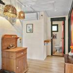Eingangsbereich mit Holzschrank, Wickerlampen und Blick in die Toilette.