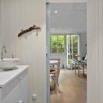 Badezimmer mit Waschbecken und Blick in Wohnbereich mit Fenster