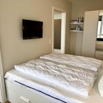 Bedroom with bed, TV, and wardrobe with mirror
