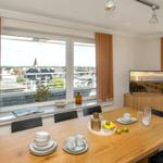 Esszimmer mit Tisch, Stühlen und Fensterblick auf Stadt.