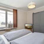 Schlafzimmer mit Bett, Kleiderschrank und Fenster mit Blick.
