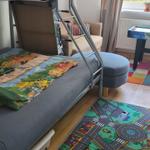 Zimmer mit Doppelstockbett, Spielteppich und Fenster mit Blick auf Garten.