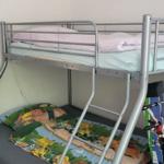 Zimmer mit Doppelstockbett, Matratzen und Kinderbettbezug.