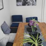 Esszimmer mit Holztisch, Pflanzen und Wandbild eines Hochlandrindes.