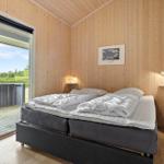 Bedroom with wooden walls, bed, and balcony door.