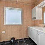 Bathroom with wooden walls, sink, and window