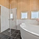 Bathroom with shower and bathtub, wooden walls and windows