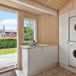 Apartment with washing machine and dryer, window and door to the garden.